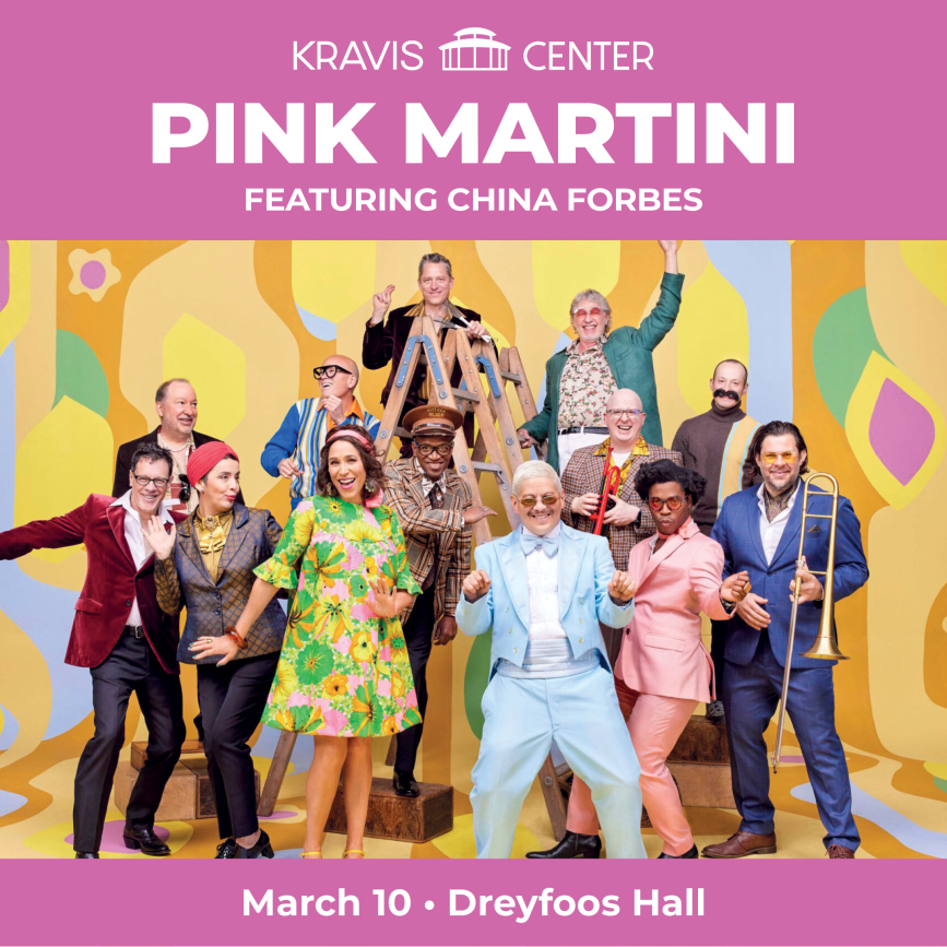 Pink Martini, featuring China Forbes, performing on stage at Kravis Center, with musicians playing a variety of instruments, as part of a WDNA 88.9FM community event.
