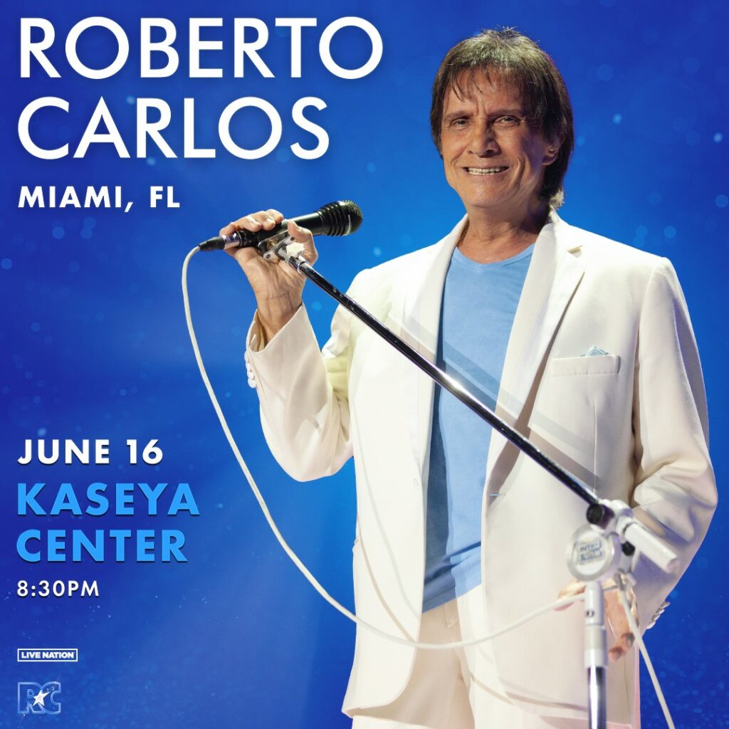 Roberto Carlos performing live at the Kaseya Center in Miami on June 16, 2024, dressed in a white suit and holding a microphone.