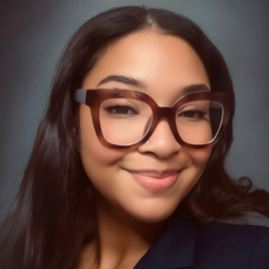 Ariel Trawick, the new Membership Coordinator, smiling and wearing glasses. She is a diligent professional with leadership and management experience, and has previously volunteered during a membership campaign.