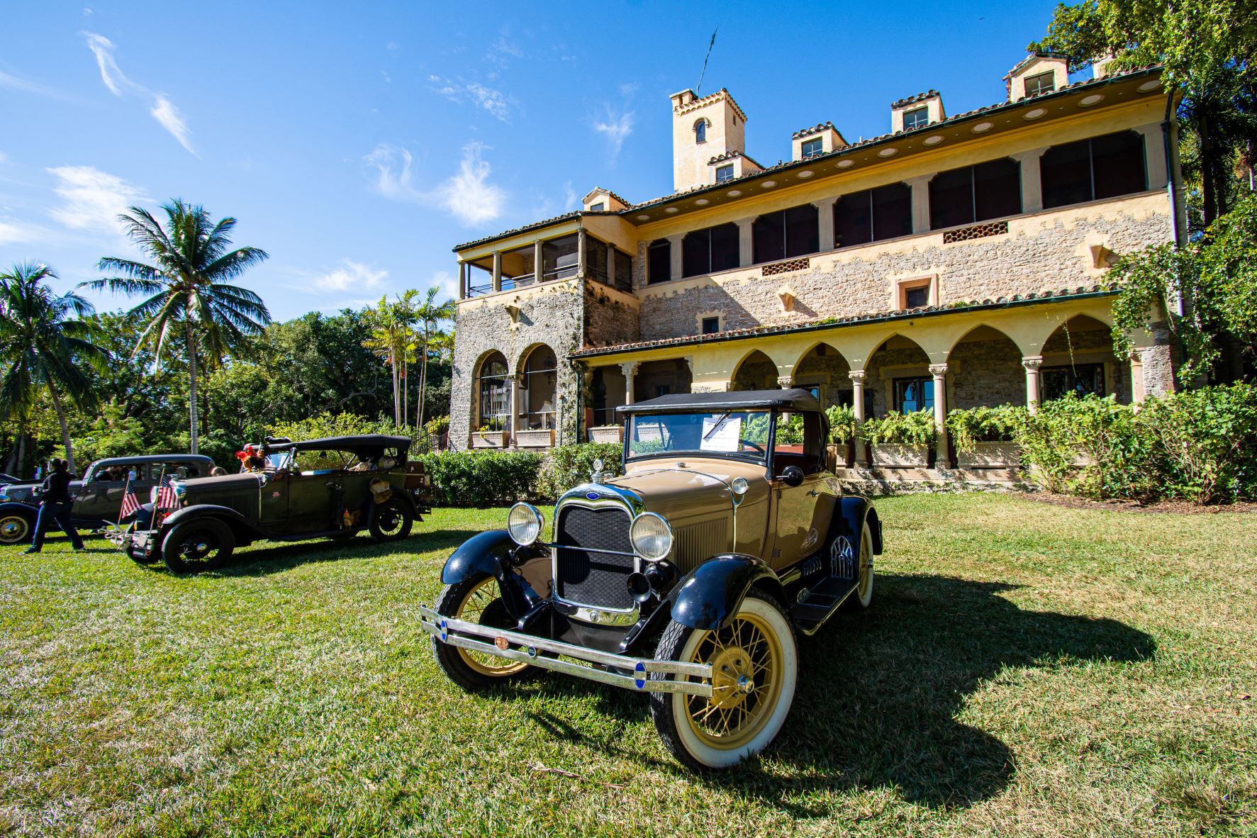 Vintage cars displayed in front of the historic Deering Estate during the Vintage Auto Show, highlighting classic automotive elegance.